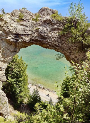 “Bicycle Arch” photograph by Ellen Greeney captures a lone biker riding in Mackinac Island State Park in Michigan on Lake Huron. The Arch Rock is nearly 15 stories tall of natural limestone. Photo by Ellen Greeney