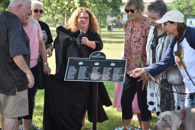  Families of the dogs unveil the plaque honoring pet fire victims at the Georgetown Bark Park.