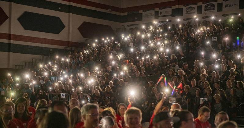 Georgetown Independent School District staffers hold up lights after a power outage during a convocation for teachers and staff held in the East View High School gymnasium on Tuesday, August 8, 2023.  The  power outage resulted in a shortened session. Photo by Andy Sharp. 