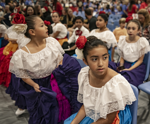 Alyssa Gordillo, 10, front, and 9-year-old Marilyn Medel, back left, members of the G.I.S.D. Ballet Folklorico dance troupe, wait to perform with their group during a convocation for teachers and staff held in the East View High School gymnasium on Tuesday, August 8. Photo by Andy Sharp. 