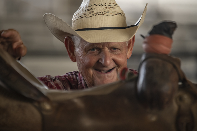 Rex Sandifer, 75, of Elgin, gets ready to mount his horse named Dollar to compete in Tiedown Roping.