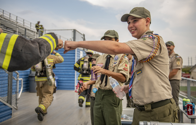 15-year-old Cameron Taylor, front, and Corwin Diaz, 15, (partially visible behind Cameron), both with Boy Scout Troop 1096, were on hand to offer hydration drinks and encouragement to participants.