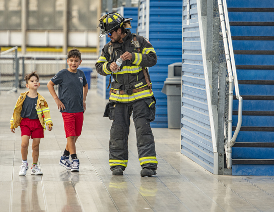 Georgetown firefighter Jonathan Marquez, right, walks with his sons, including Micah, 6, and Jude, 10, after all three completed the Memorial Stair Climb together.