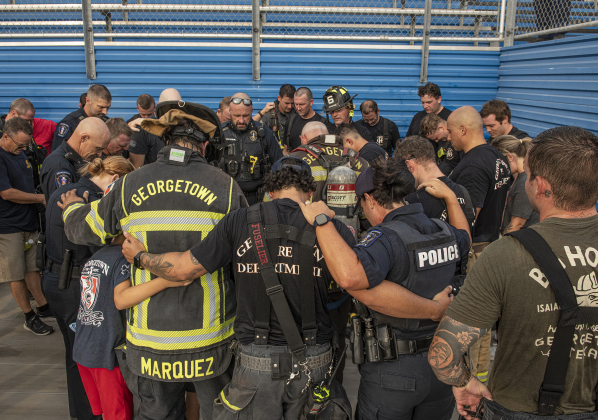 Police officers and firefighters come together for a closing prayer at the conclusion of this year's  Memorial Stair Climb, held at Birkelbach Field on Monday, September 11, 2023.
