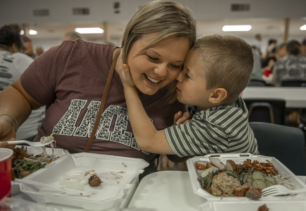 6-year-old Mason Rhea shared a tender moment with his mother Denise Rhea while they dined together in the parish hall.