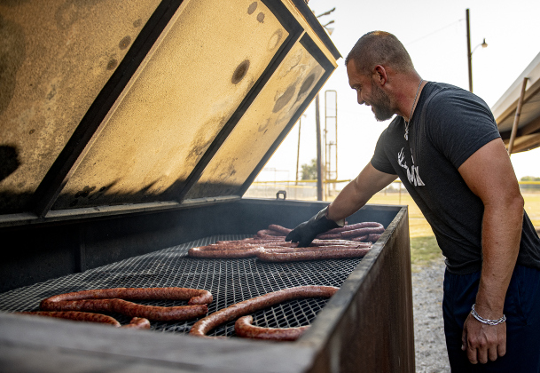 Kyle Janke oversees sausages in the smoking pit area.