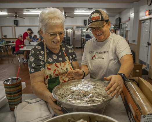 Shirley Volek, left, and her daughter Jolene cover just-made slaw in the recreation hall kitchen.