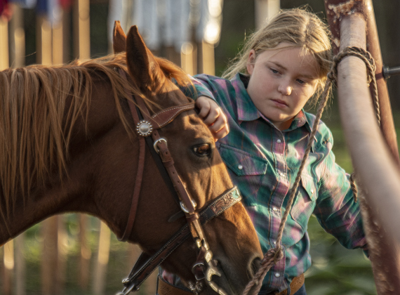 Kendall Ford spends quiet time with a  horse when not competing in Barrel Racing.