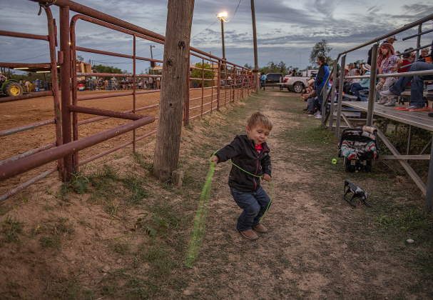 2-year-old Bronc Winkler, whose dad is Team Roping member Kade Winkler, tries out his  own roping skills  from the spectator stands.