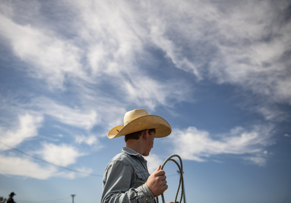 13-year-old Mason Simpson, a participant in Breakaway Roping and Team Roping prepares himself for competition.