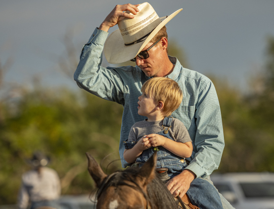 Team Roping participant Tommy Ward spends time with his son Ellis, 2, before competition.