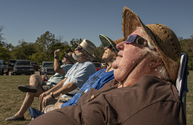 (Front to back) Keri Davis, Vicki Goodrich, Vick's husband Robert Goodrich and Duane Davis (Keri's husband) watch the annular eclipse during a Saturday, October 14, 2023 gathering at Berry Springs Parks & Preserve,  hosted by Friends of Berry Springs Park.  An annular eclipse occurs when the moon gets between the earth and sun.  The eclipse's visibility was approximately 89% in the Austin area.  