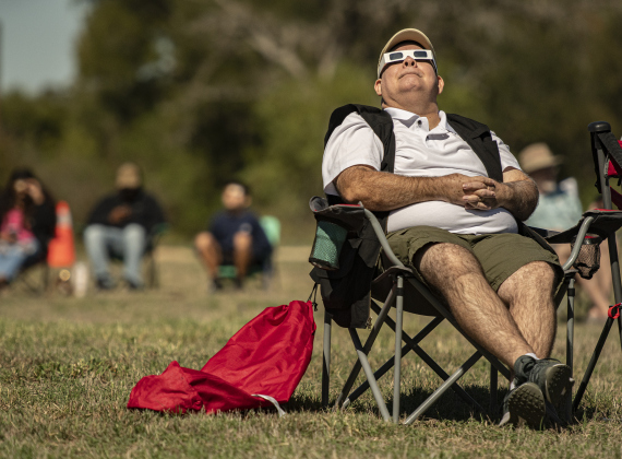 Alfred Padilla enjoys watching the annular eclipse during a Saturday, October 14, 2023 gathering at Berry Springs Parks & Preserve,  hosted by Friends of Berry Springs Park.  An annular eclipse occurs when the moon gets between the earth and sun.  The eclipse's visibility was approximately 89% in the Austin area.