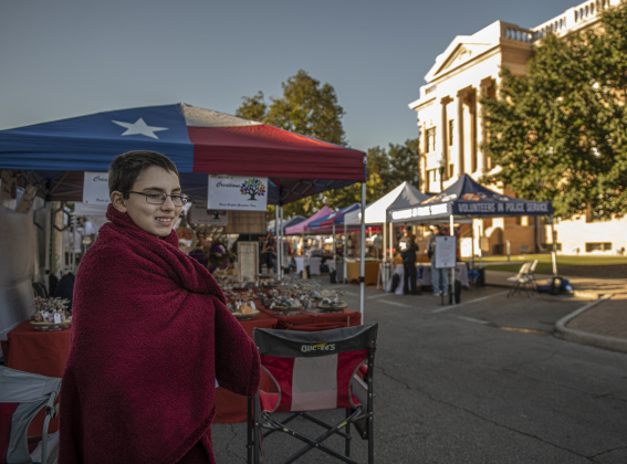 11-year-old Joshua Mason stays bundled up on a cool morning. His family, from near Marble Falls, oversees their family business, Mason's Creations.