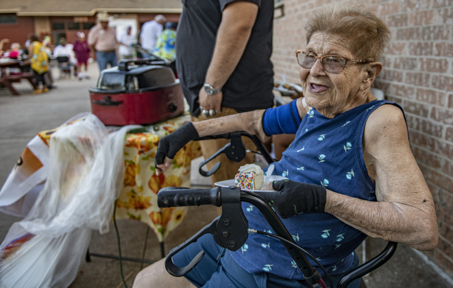 86-year-old Ophelia Ontiveron enjoys the evening  during a National Night Out event held at Stonehaven Apartments.  Ontiveron made tamales to distribute to attendees.