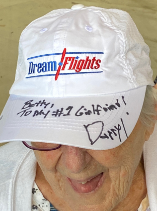 Marine veteran Betty McCann dons her DreamFlights hat autographed by founder, president and pilot Darryl Fisher.