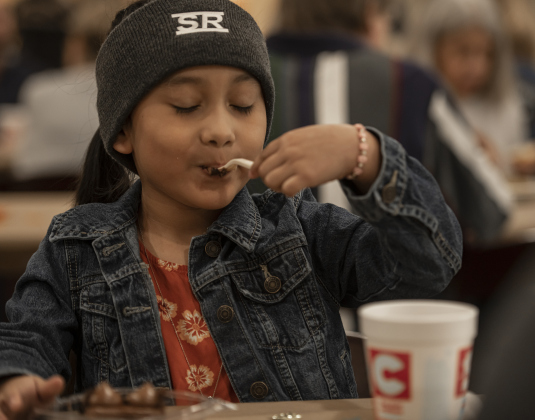 5-year-old Sophia Avalos enjoyed a slice of chocolate cake during  the Community Thanksgiving, held at the Georgetown Community Center in San Gabriel Park on Thursday, November 23, 2023.