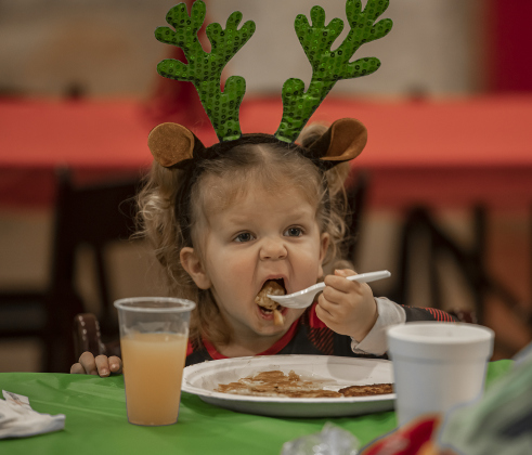 2-year-old Parker Williams opens wide for a bite of her breakfast.