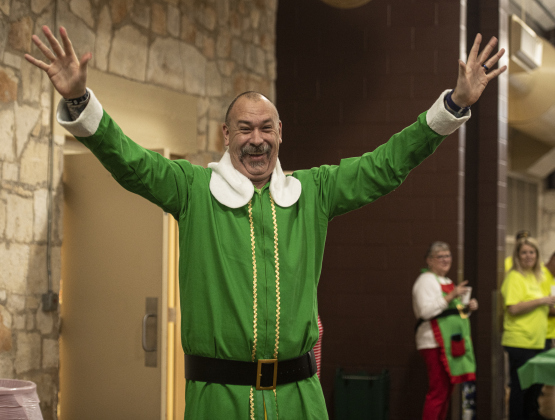 Georgetown firefighter Rebel Paulk, dressed as Buddy the Elf, shouts "I know him!" when Santa arrives at the San Gabriel Community Center for Breakfast With Santa on Saturday, December 23, 2023.  At 6'11" Paulk is a very tall elf!
