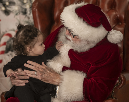 8-month-old Grace Billingsley makes a close inspection of Santa's beard.