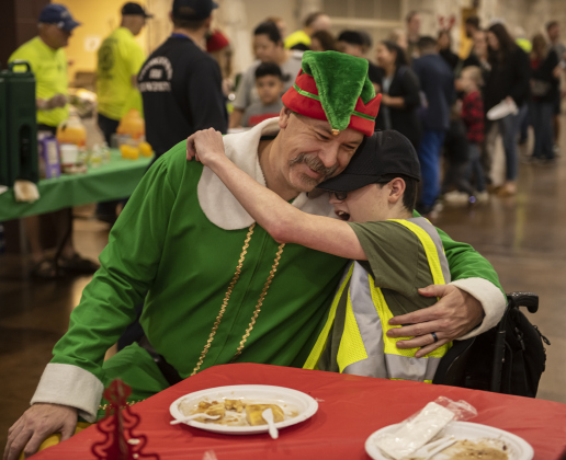 Georgetown firefighter Rebel Paulk, dressed as Buddy the Elf, gives a big hug to attendee Logan Parker, 16.