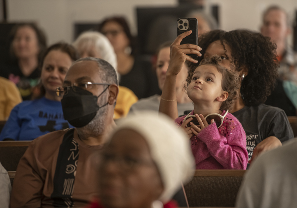 3-year-old Nora Marmion relaxes while her mom Olivia Marmion takes a photo at during the program at Macedonia Baptist Churchduring the Dr. Martin Luther King, Jr. march and program held on Monday, February 19th, 2024.  They were joined by Nora's dad (Olivia's husband) Bill Marmion