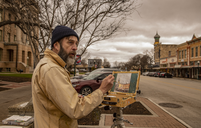 Paul Matula, a Plein Air painter from Austin, creates a painting at the corner of 8th and Main Streets on Saturday morning, January 27,2024.  He was joined by other Plein Air painters from Round Rock and Austin on a cloud-filled morning with temperatures near 50 degrees. Photo by Andy Sharp. 