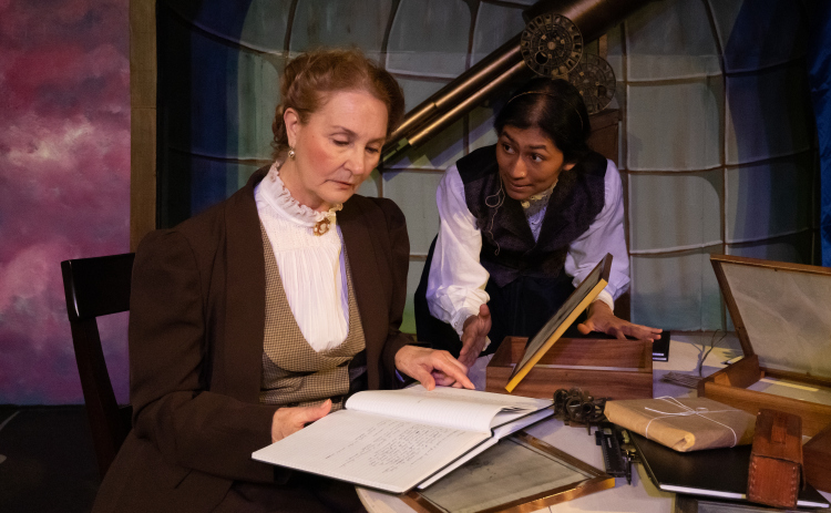 Joanna Gunaraj, right, plays astronomer Henrietta Swan Leavitt in the Palace Playhouse production of “Silent Sky.” Ms. Gunaraj is joined by Linda Myers, who portrays astronomer Annie Jump Cannon in the show. Courtesy Suzanne McBride