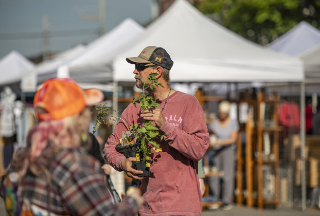Shopper Keith Anderson walks along Seventh Street with tomato plants he purchased during Market Days, held Saturday, April 13.