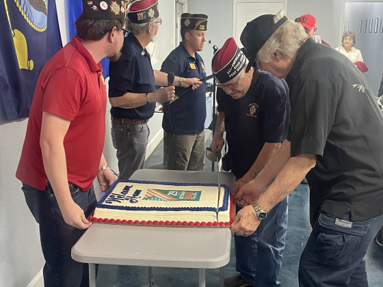 Quartermaster Jim Holden cuts the first slice of a cake March 29.