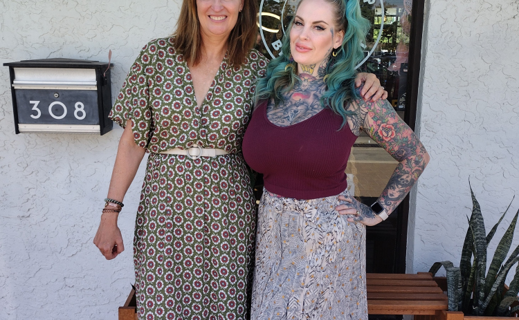 Kelly Ann Carney, owner of Therapie Boutique, and Kandy Mitchell, owner of Silver Moon Curios, stand in front of the Co-Op building at 308 West Eighth Street.