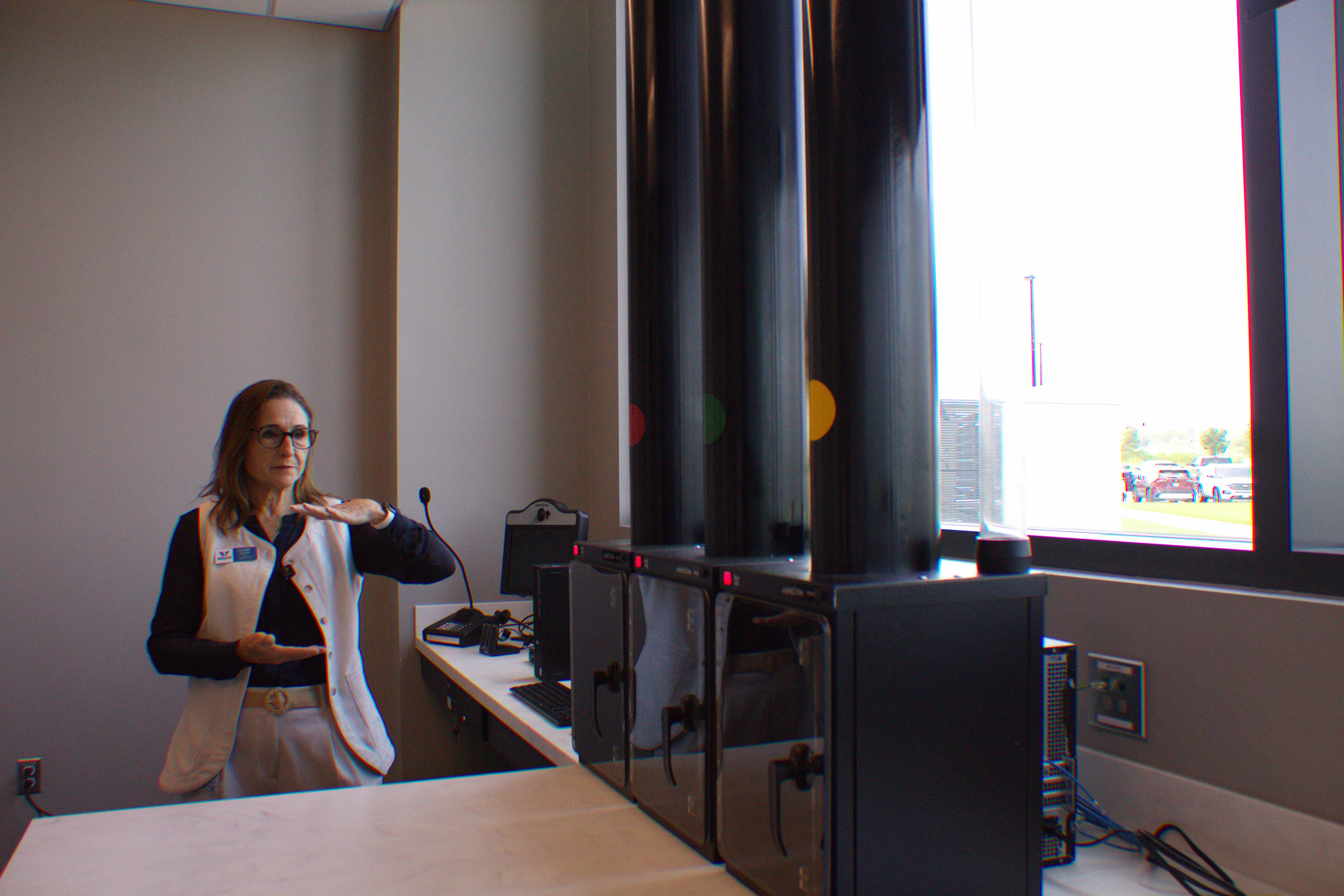 Connie Odom, Williamson County's director of communications and media relations, gives a tour of the new Tax Assessor-Collector's office at the new County Administration Building on June 22. This drive-through will allow residents to get new license plates. Photo by Nalani Nuylan.