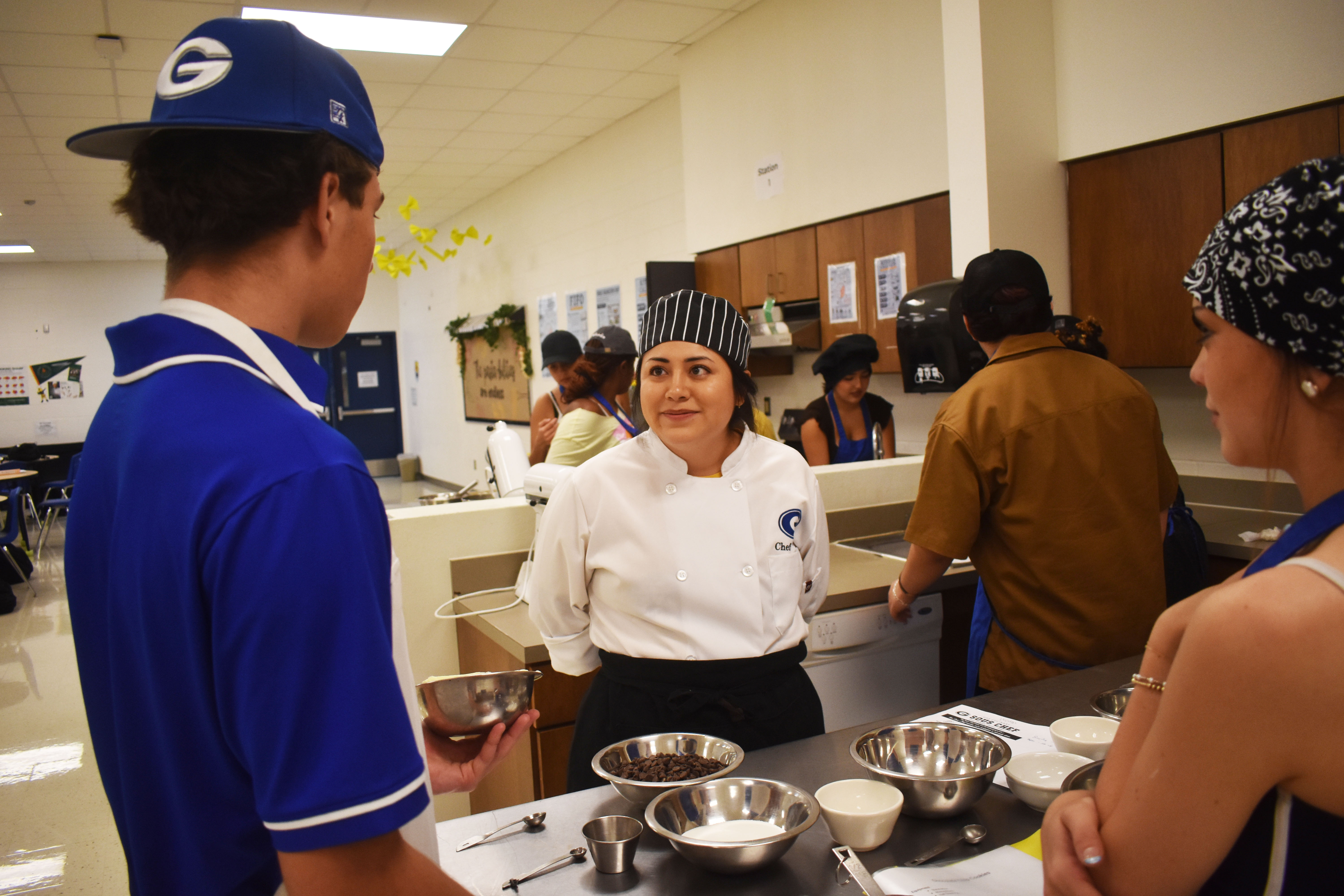 GHS Culinary instructor Karina Davila helps students Brayden Bratton and Payton Ragsdale get started on a batch of cookies. 