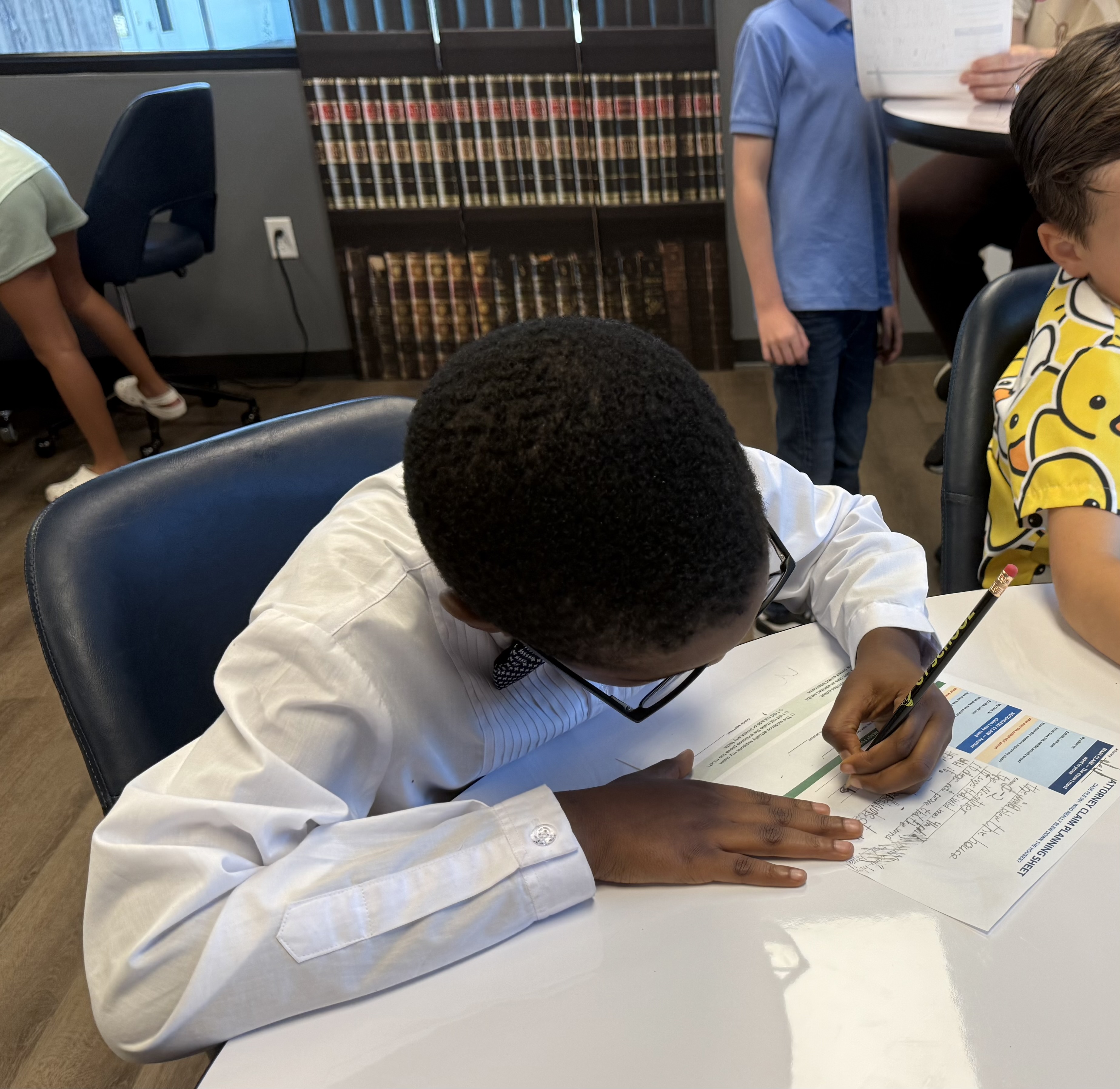 JJ Ahanobi-Ikekwere, age 7, works on a mock-trial case workshop. He is figuring out whether or not the big bad wolf blew down the pigs house. Photo by Abbey Archer