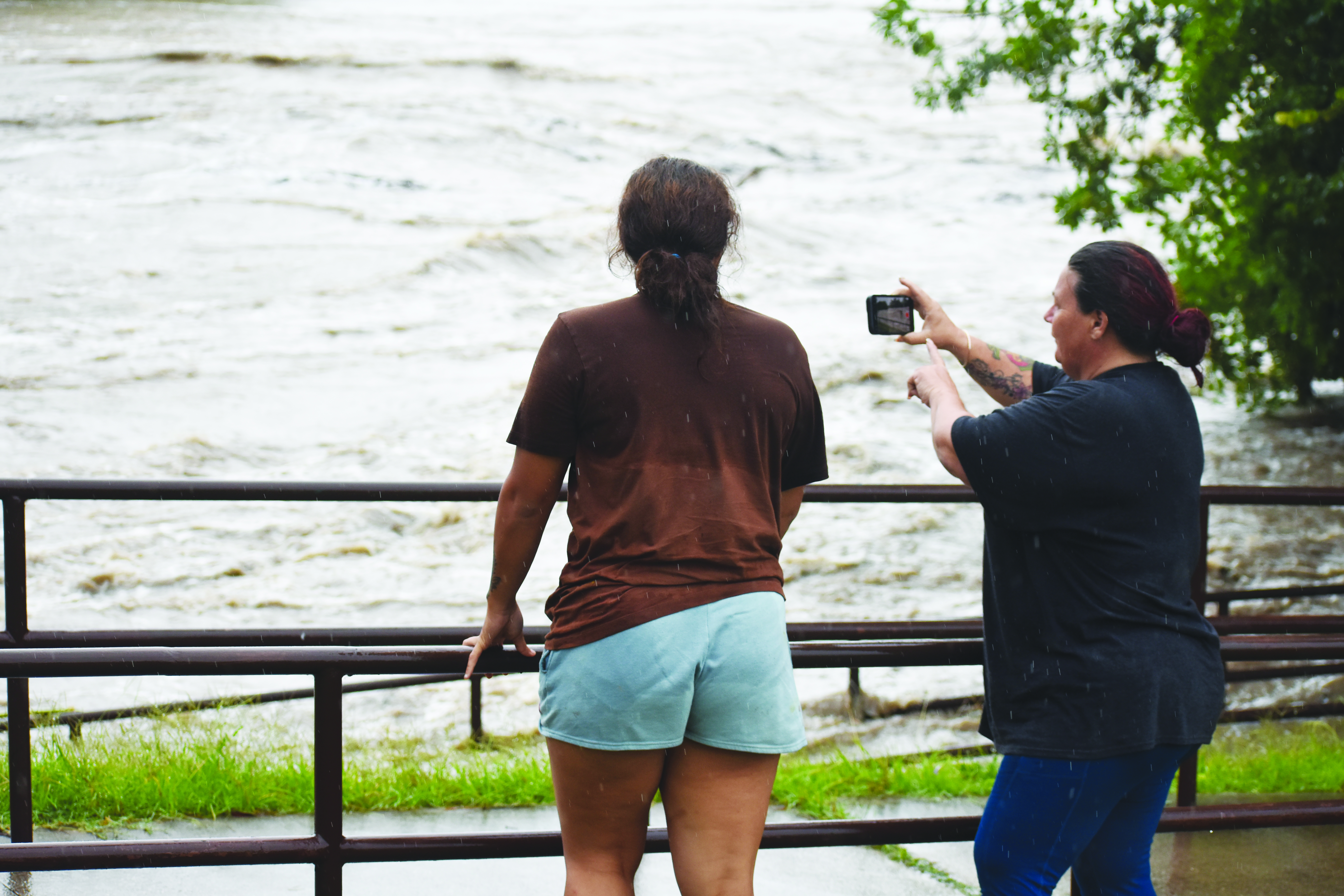 Michelle and Aliyarn Patterson, take a video of the raging of the San Gabriel River along North College Street at San Gabriel Park. 