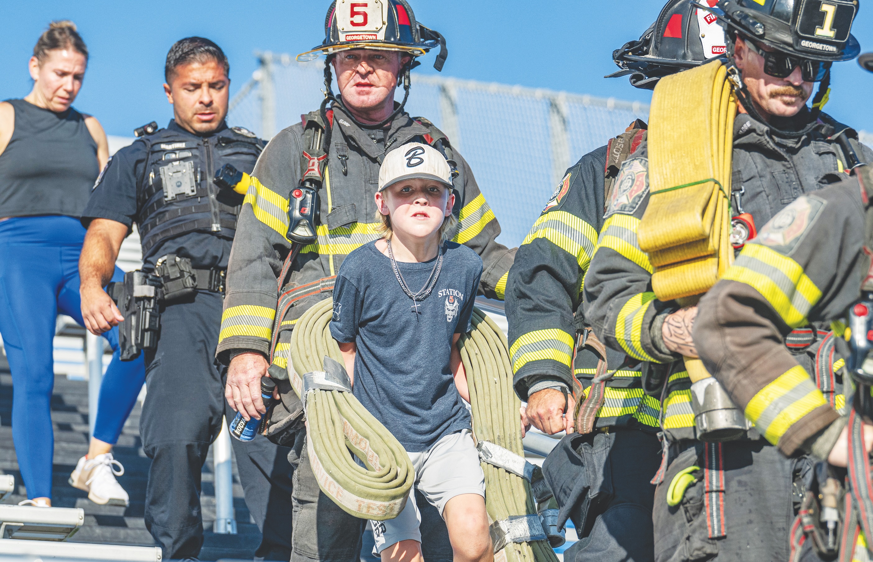 10-year-old Read Lockwood (carrying hose) walked with his father, Georgetown Fire Department Captain Trey Lockwood (behind Read) during the Memorial Stair Climb held at Birkelbach Field  on Thursday, September 11, 2025 to commemorate  the 24th anniversary of the attacks on United States soil on September 11, 2001.   Photo by Andy Sharp
