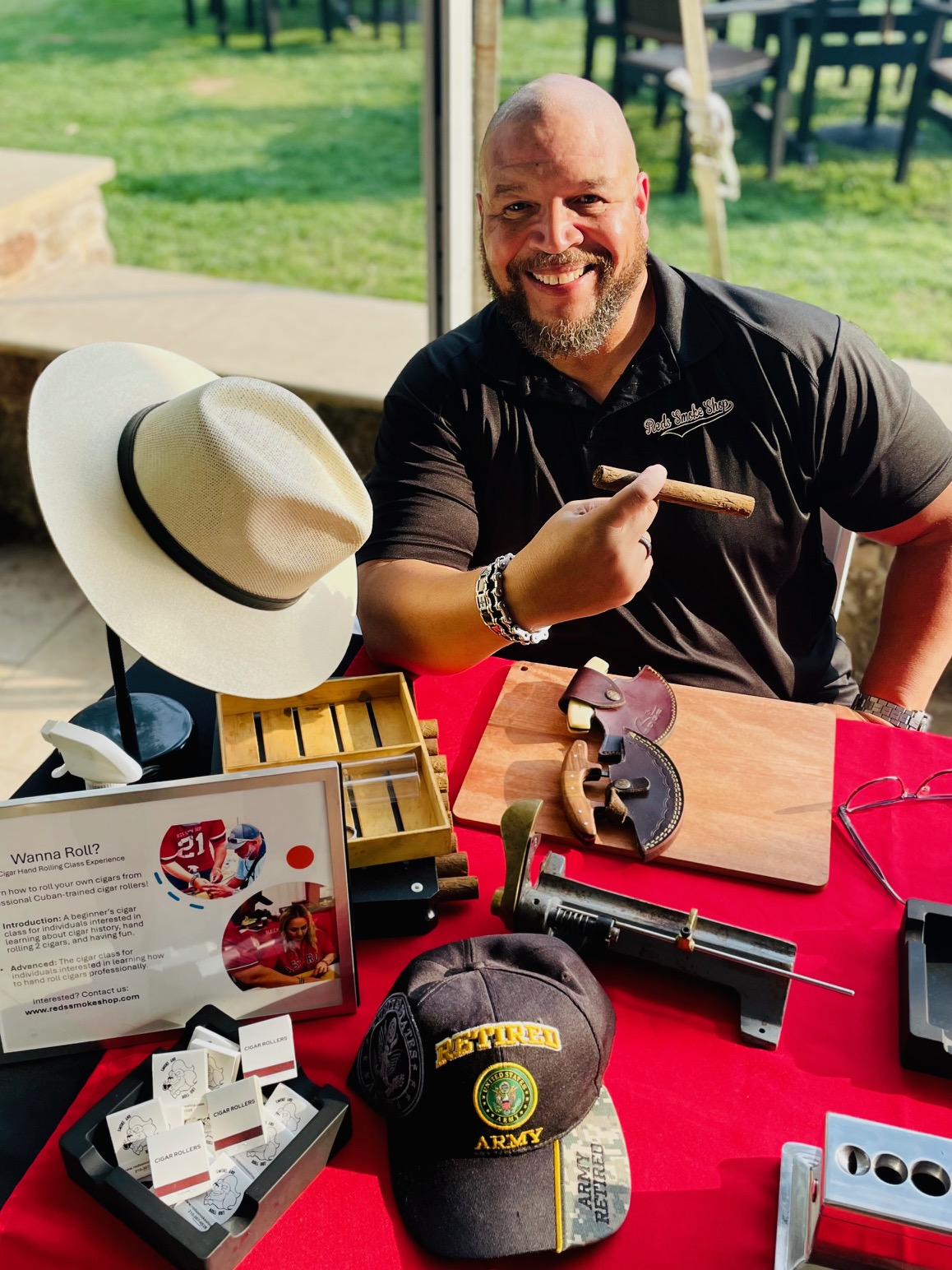 James Sims, co-founder and cigar roller at Red’s Smoke Shop, sitting with cigar rolling tools. 