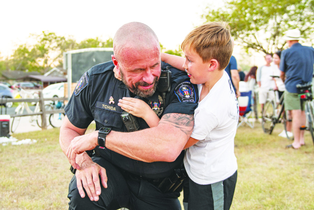 City of Georgetown Police Chief Cory Tchida tries out a playful Jujitsu move with Jaxon Phelps, 7, during a National Night Out gathering Tuesday. PHOTOS BY ANDY SHARP