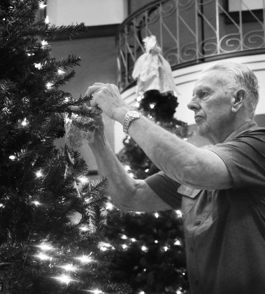 Jack Callison hangs an ornament on the tree to represent a victim of a violent crime in 2019.