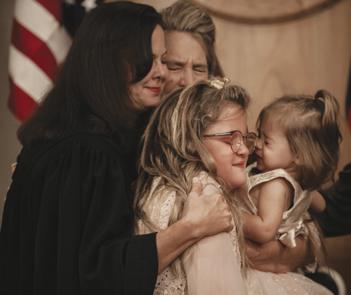 Judge Brandy Hallford, left, joins in a hug with mom Noelle Villines and her children, including Kenzleigh, 9, front, and her 19-month-old sister Kyndall. Noelle and her husband Maurice Villines also adopted a son, 11-year-old Kaycen.