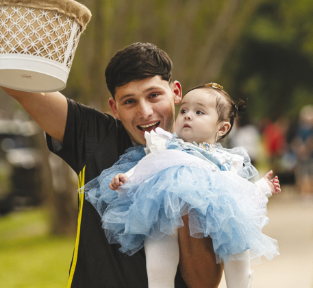 Sebastian Aguilar with his 8-month-old daughter Paulina trick-or-treat on Halloween night along Main Street in Old Town Monday, October 31.