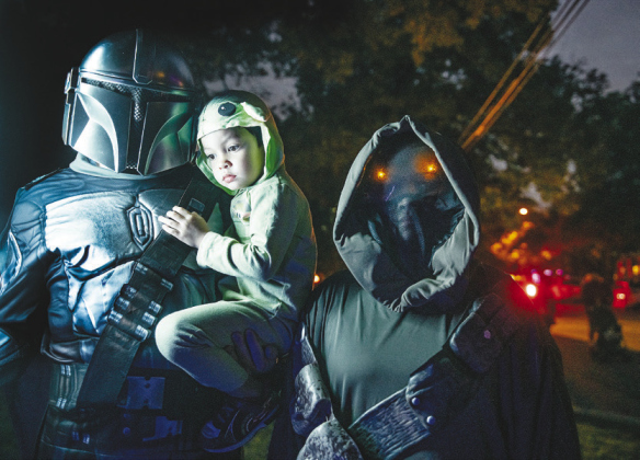 Mark Wilson, his wife Charlin Wilson and their son Ethan, 3, as Baby Yoda, were were dressed as characters from The Mandalorian.