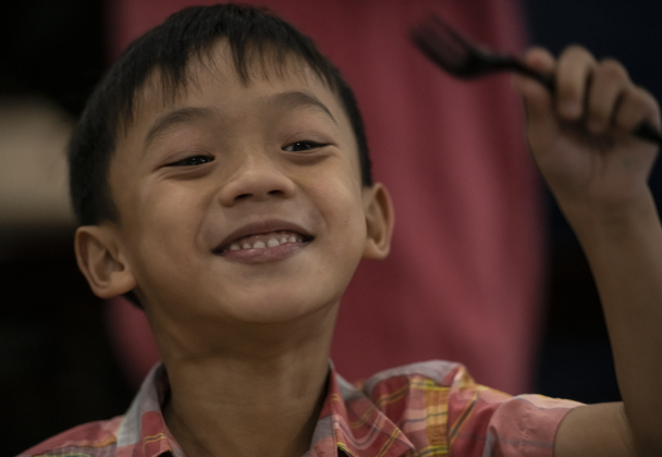 Oliver Nguyen, 6, enjoys a meal with his family.