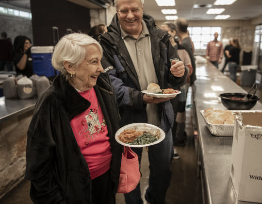 Sondra Baska, left, and her son Brian Cunningham make their way through the serving line during Georgetown’s community Thanksgiving.