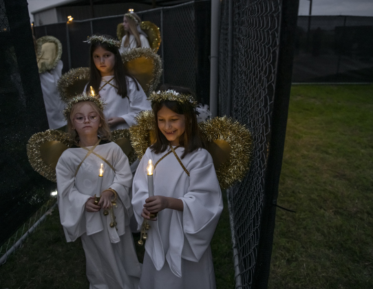 Angels, including Heidi Walters, 5, front left, Olivia Gutierrez, 7, front right, and Olivia's sister Isabel Gutierrez, 10, in back, prepare to take their places in the manger scene.