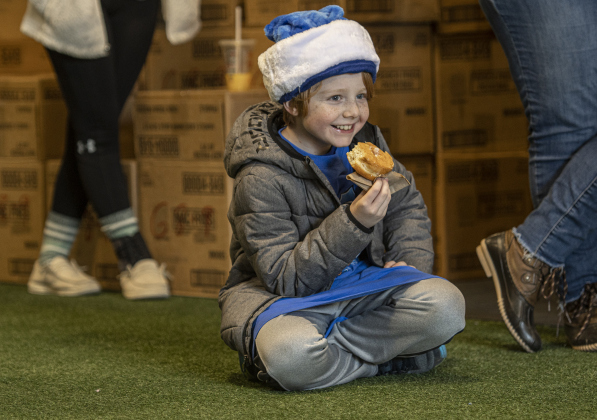 T.C. Grasse, 8, whose parents are Georgetown Police Department commanders Erik Grasse and his wife Renee Koog, takes a doughnut break before handing out more gift boxes.