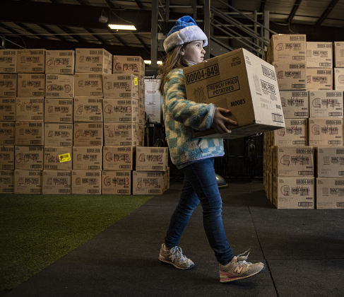 Layne Robey, 8, helps hand out gift boxes.
