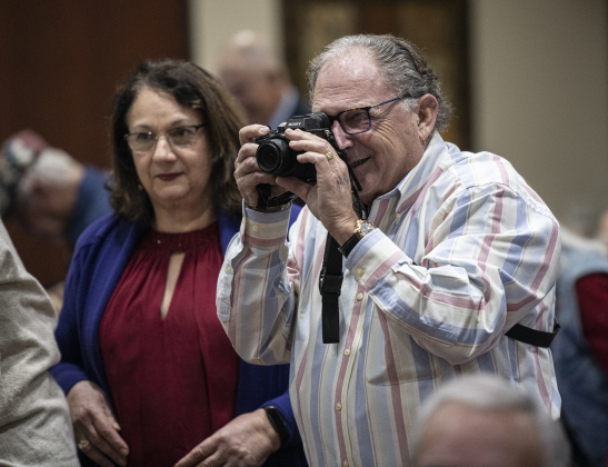ack Lester, outgoing president of Congregation Havurah Shalom, takes photos during the first night of Hanukkah on Sunday, December 18, 2022.