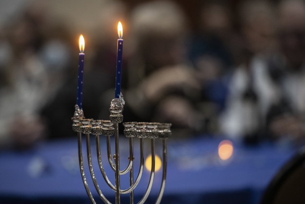 menorah's candles glow during a gathering  of  Congregation Havurah Shalom during the first night of Hanukkah on Sunday, December 18.