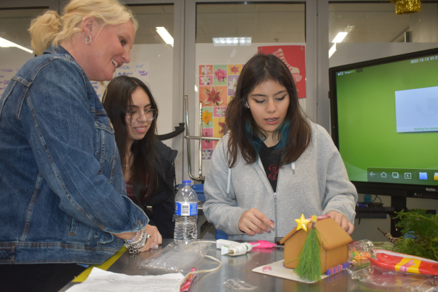 Floral Design instructor Amy Beran works with Georgetown High School senior floral students Jasmin Garcia Camargo and Lydia Rojas on creating gingerbread houses incorporating floral elements. (Katherine Anthony)